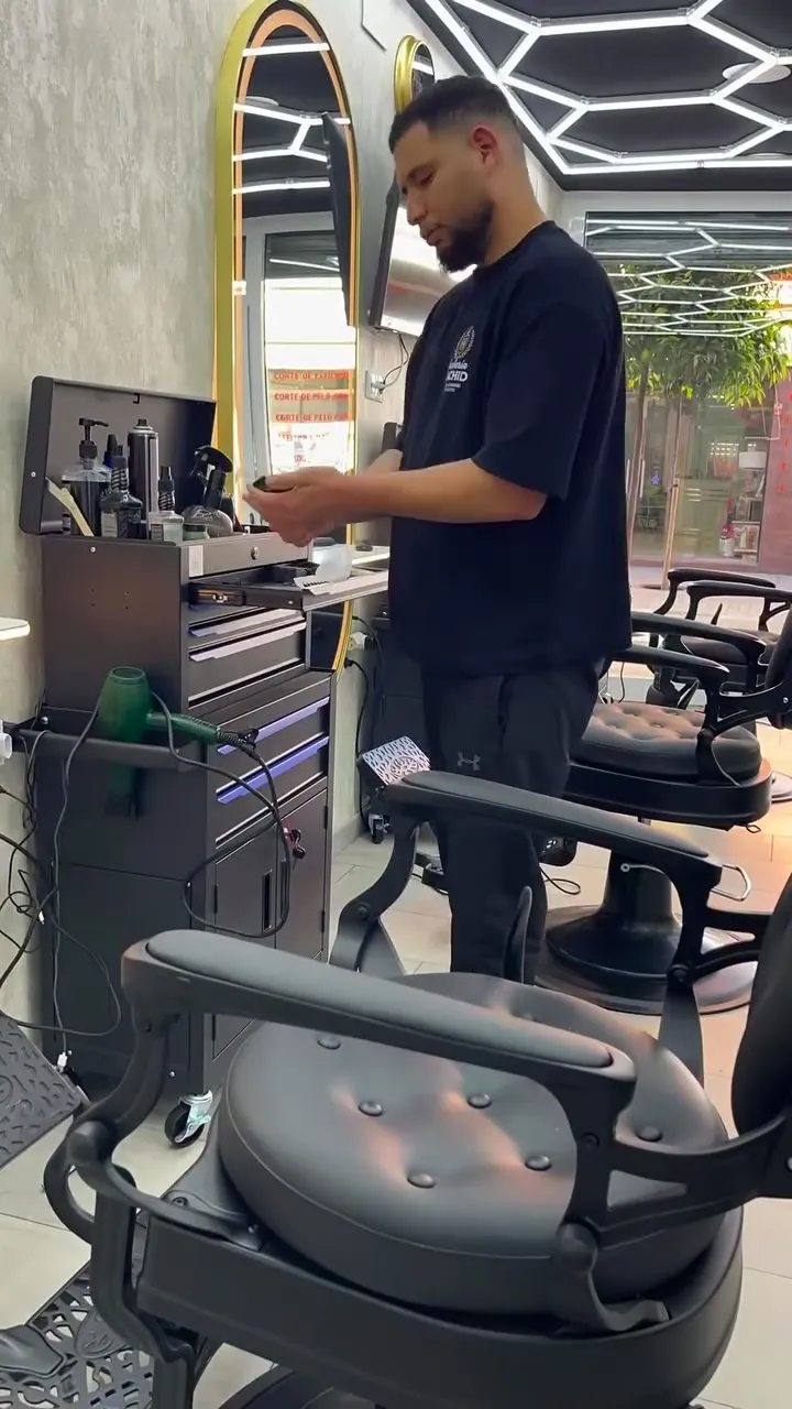 Barbero preparando su puesto junto al carro de herramientas
